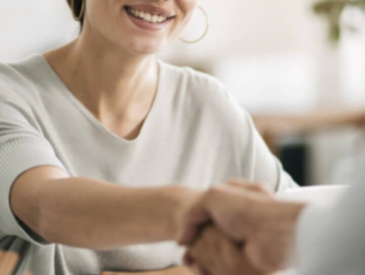Woman smiling shaking hands with doctor