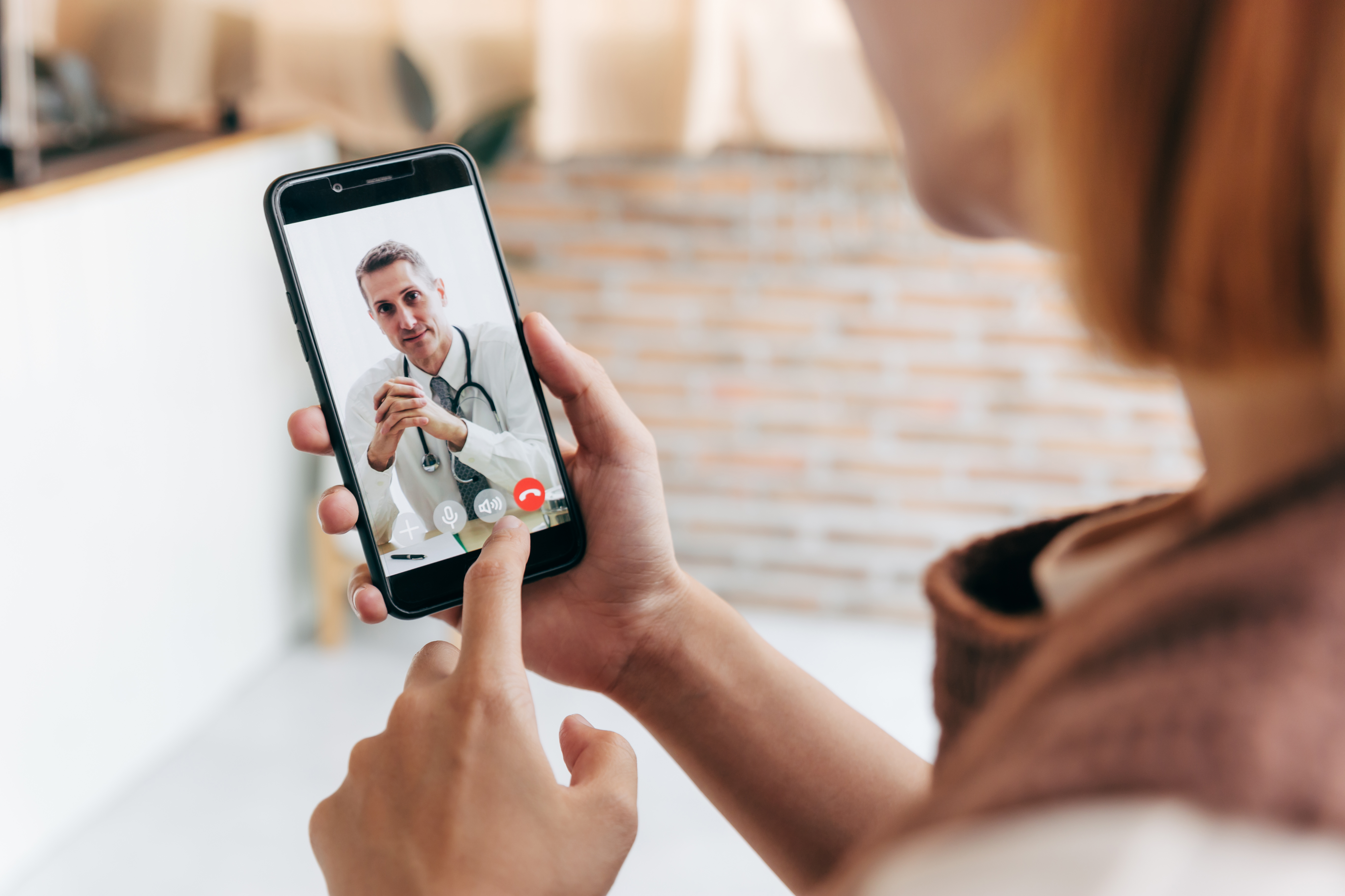 Person speaking with doctor through video on smartphone